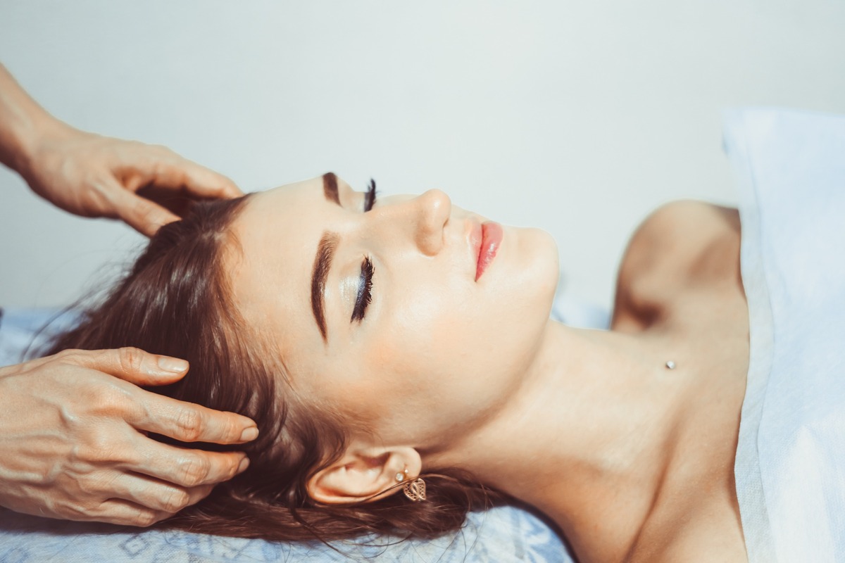 manos de terapeuta en sienes mujer